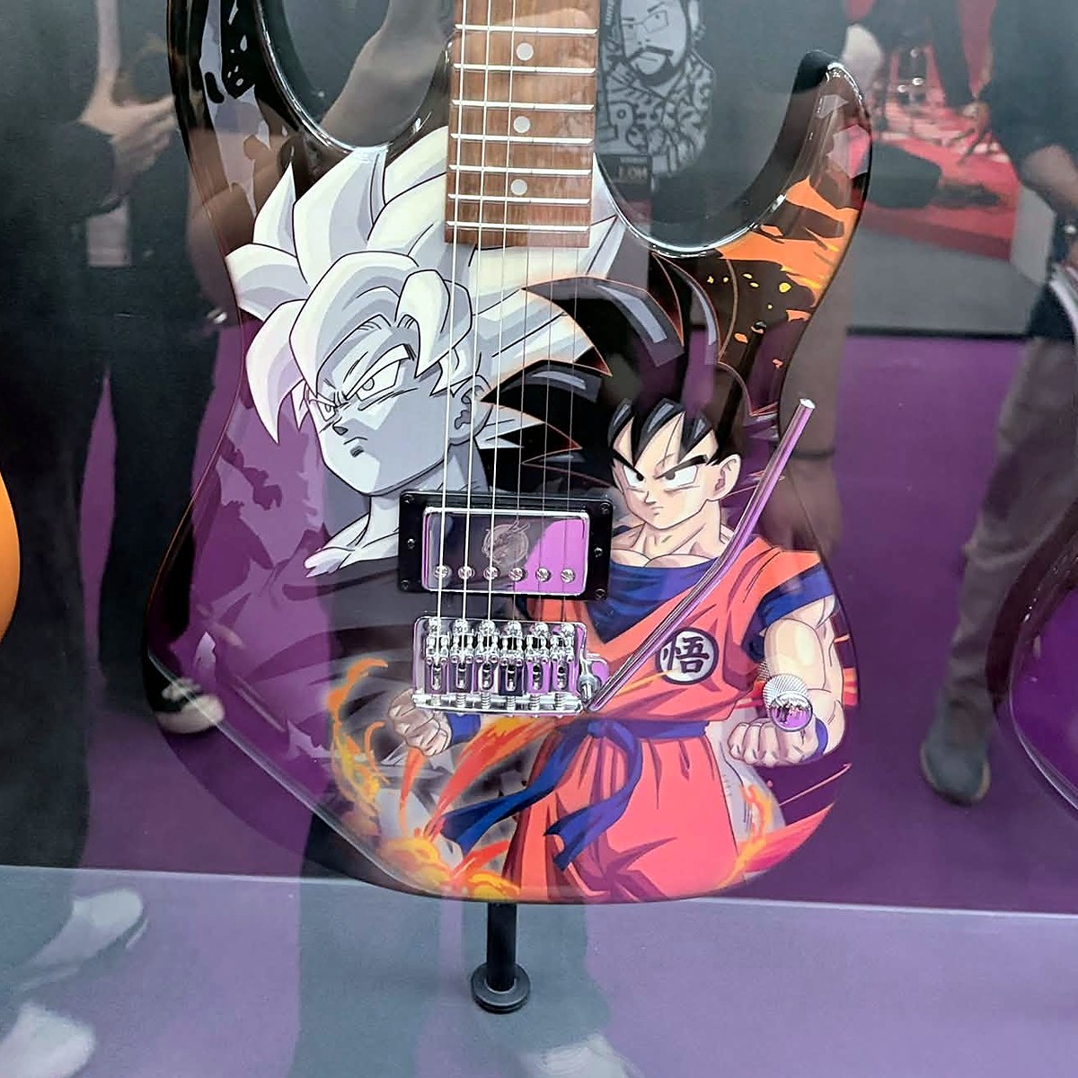 Ảnh thực tế thân guitar Ibanez Son Goku Siêu Xayda trong tủ kính, thấy rõ artwork, humbucker và ngựa T106