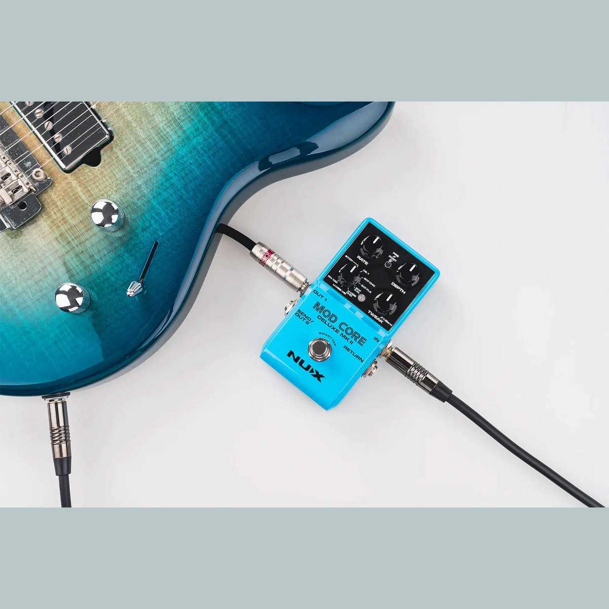 Phơ Modulation NUX Mod Core Deluxe MKII – NUX Mod Core Deluxe MKII đã cắm dây đặt cạnh guitar điện