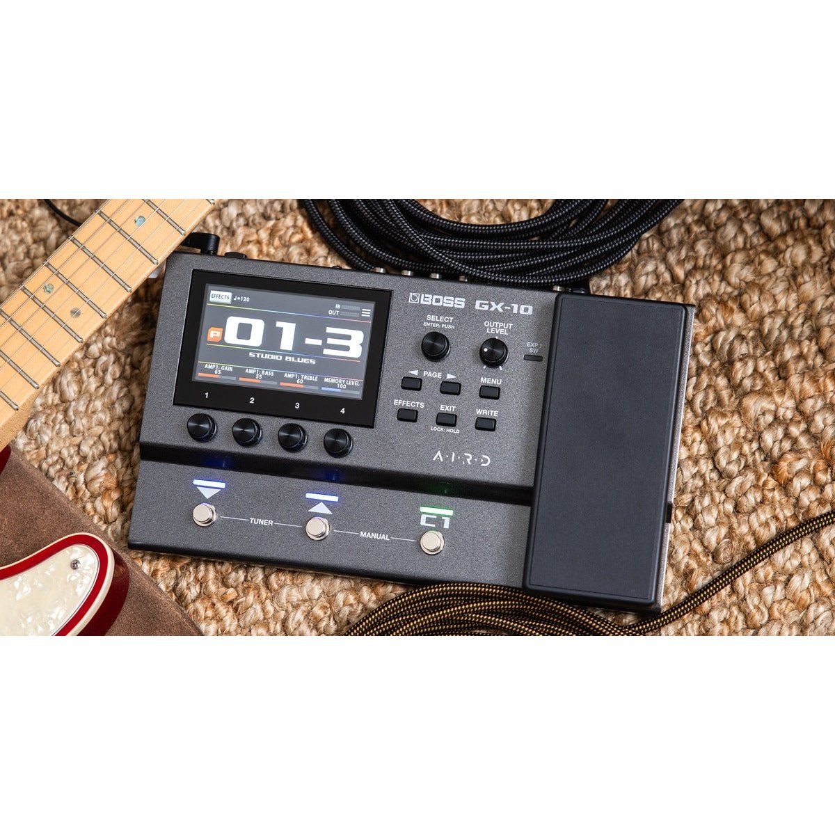 Phơ Tổng BOSS GX-10 – đặt trên thảm cạnh đàn guitar, màn hình màu hiện patch 01-3