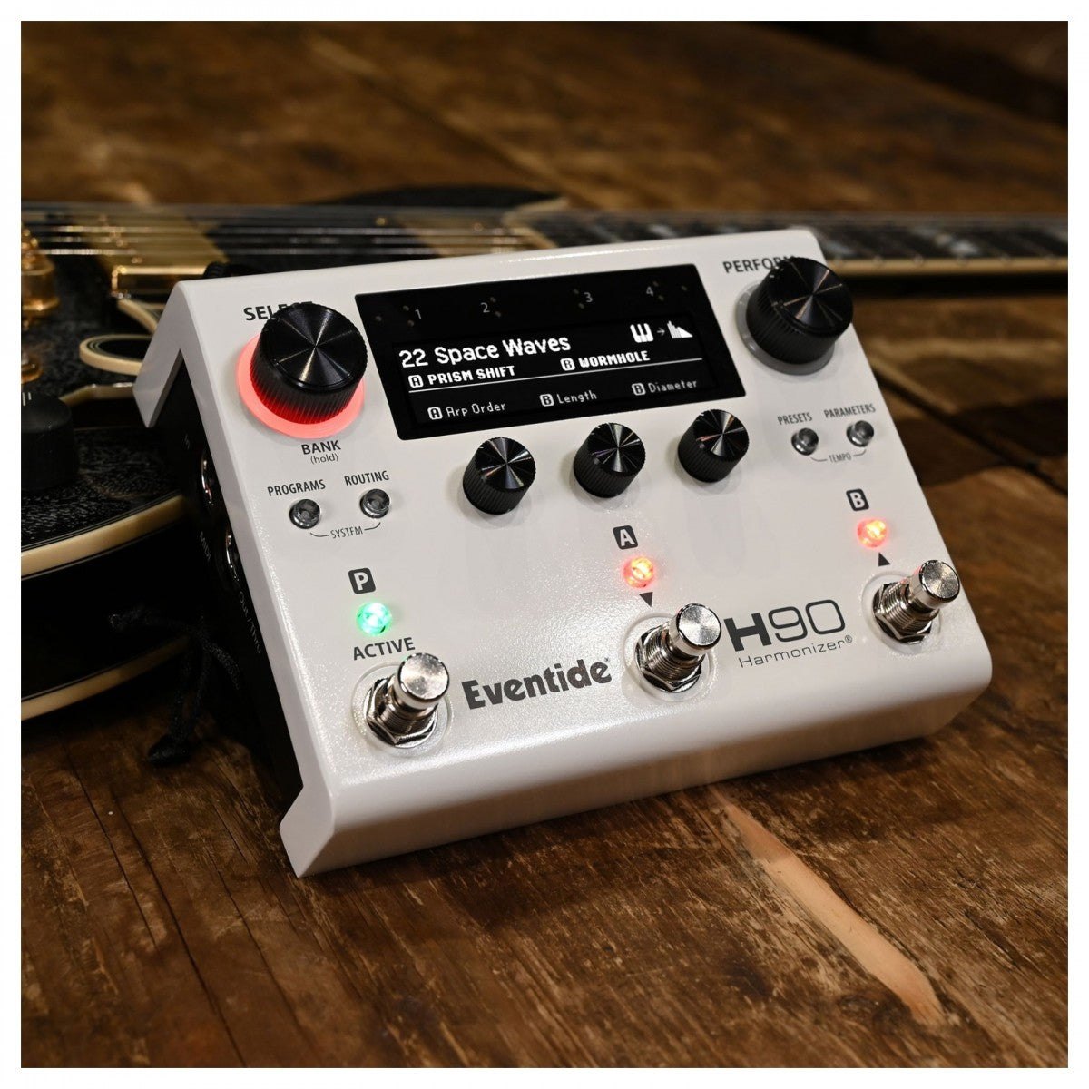 Phơ Tổng Eventide H90 Harmonizer – đặt trên sàn gỗ cạnh đàn guitar
