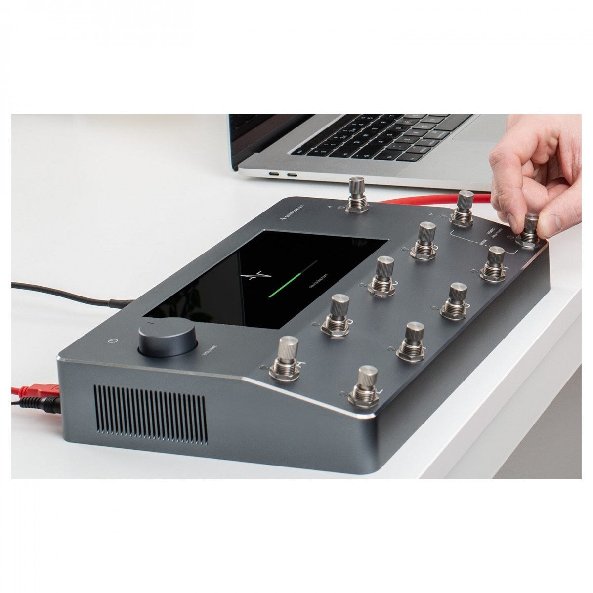 Phơ Tổng Neural DSP Quad Cortex – đặt trên bàn cạnh laptop, tay đang chỉnh footswitch
