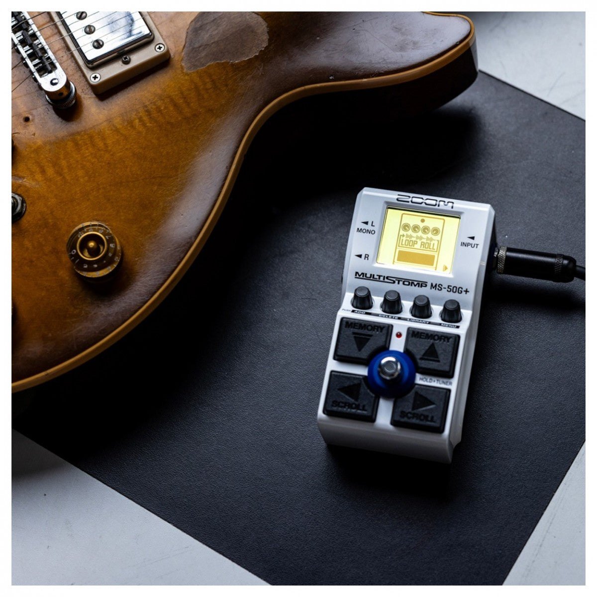 Phơ Tổng Zoom MS-50G+ MultiStomp – đặt cạnh đàn guitar điện, đã cắm dây tín hiệu
